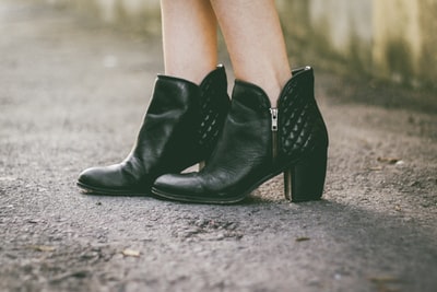 女人黑色粗高跟鞋靴子站在灰色的地板上
